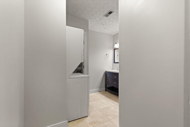 bathroom with tile patterned flooring, vanity, and a textured ceiling