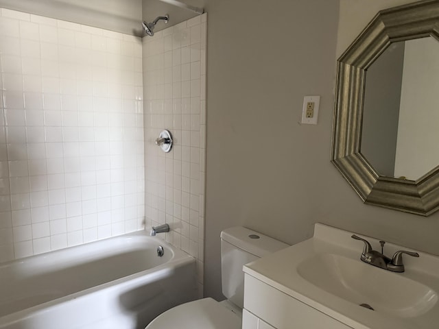 full bathroom featuring tiled shower / bath combo, vanity, and toilet