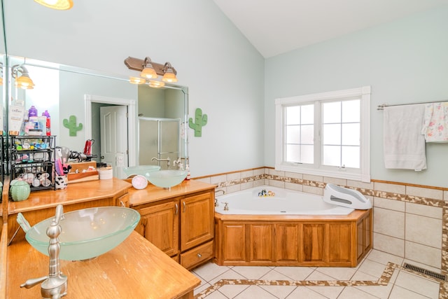 bathroom featuring visible vents, vaulted ceiling, a sink, and tile patterned floors