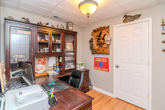 home office with an ornate ceiling, visible vents, baseboards, and wood finished floors