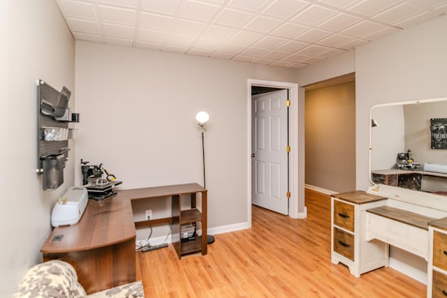 home office with baseboards and wood finished floors