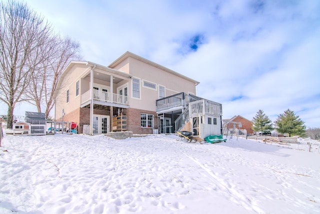 snow covered property featuring brick siding