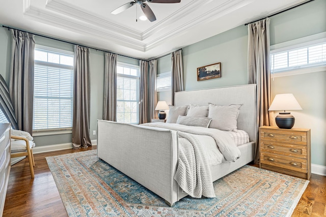 bedroom with a raised ceiling, wood-type flooring, ceiling fan, and crown molding