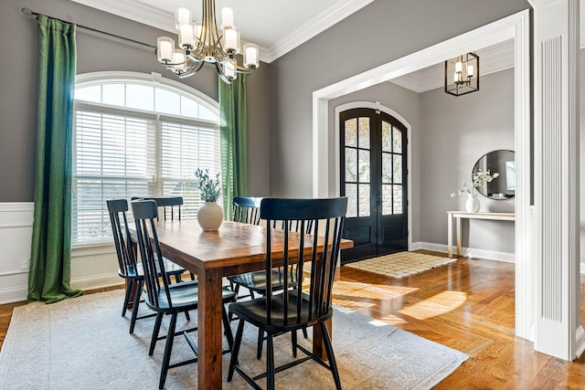 dining room with crown molding, plenty of natural light, an inviting chandelier, and french doors