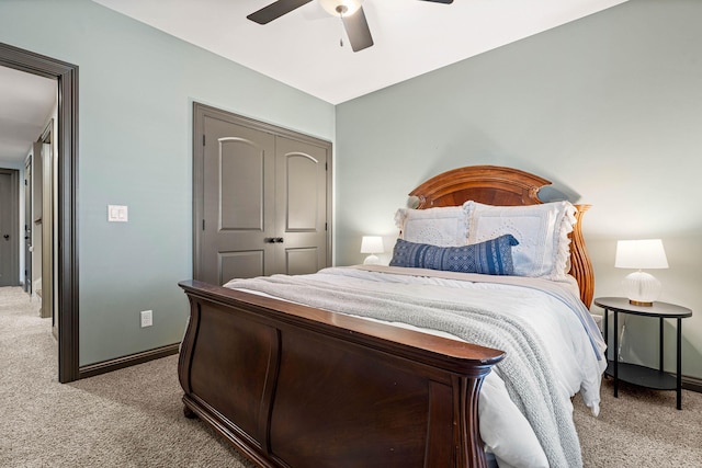 bedroom with light colored carpet, ceiling fan, and a closet