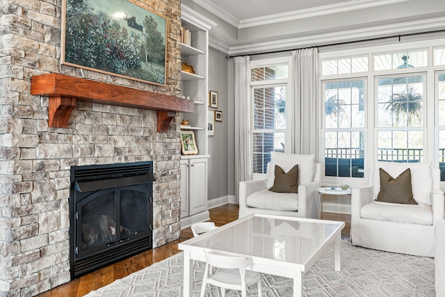 living room featuring crown molding, wood-type flooring, and a large fireplace