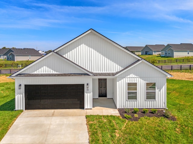 modern inspired farmhouse with a garage, concrete driveway, fence, a front lawn, and board and batten siding