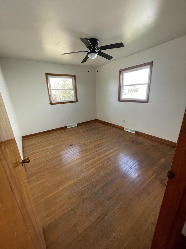 spare room featuring dark hardwood / wood-style floors, a wealth of natural light, and ceiling fan