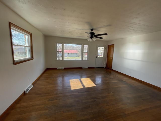 unfurnished room featuring ceiling fan, dark hardwood / wood-style floors, and a textured ceiling