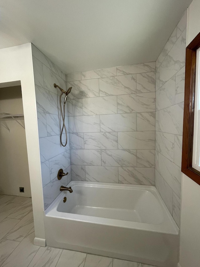 bathroom featuring tiled shower / bath