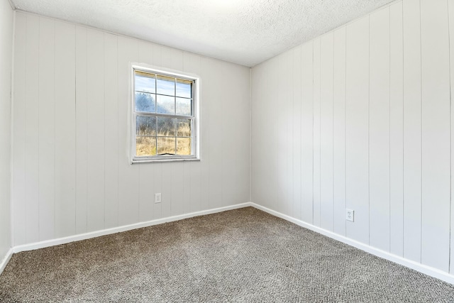 carpeted empty room featuring a textured ceiling