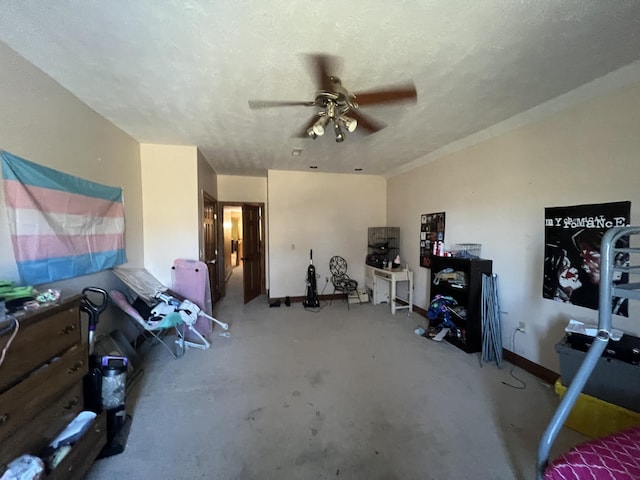 interior space featuring ceiling fan, a textured ceiling, and concrete floors