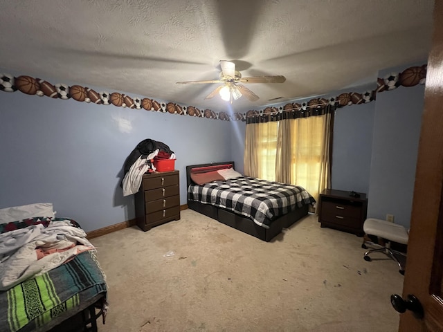 bedroom with ceiling fan, light colored carpet, and a textured ceiling