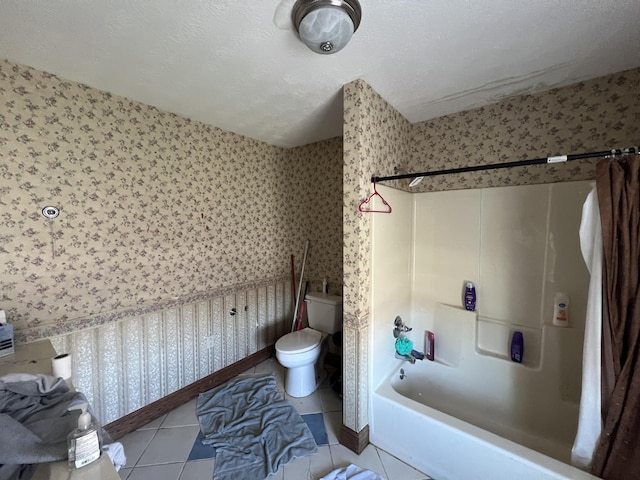 bathroom with toilet, tile patterned flooring, shower / bath combo with shower curtain, and a textured ceiling