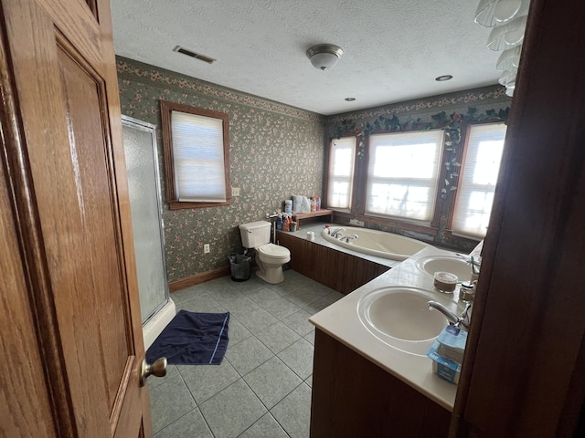 full bathroom with vanity, independent shower and bath, toilet, and a textured ceiling