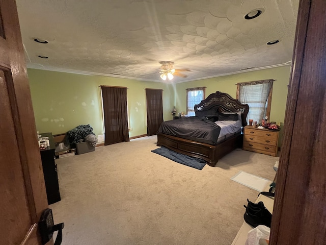 carpeted bedroom featuring ceiling fan, crown molding, and a textured ceiling