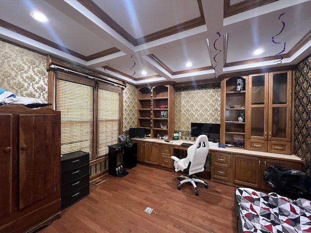 office area with coffered ceiling, hardwood / wood-style flooring, built in desk, and ornamental molding