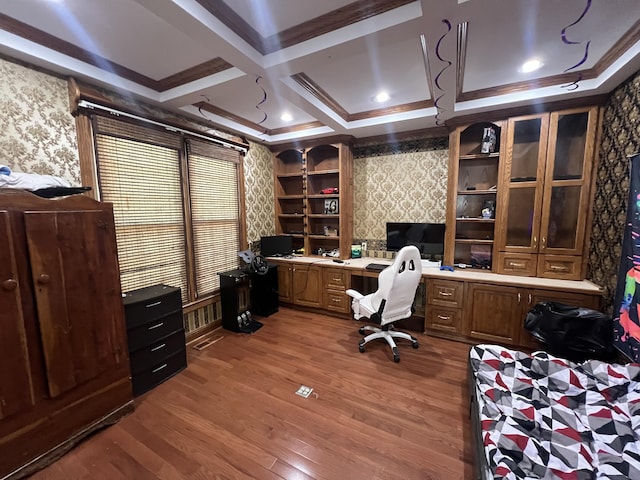 office area featuring built in desk, beamed ceiling, hardwood / wood-style flooring, coffered ceiling, and crown molding