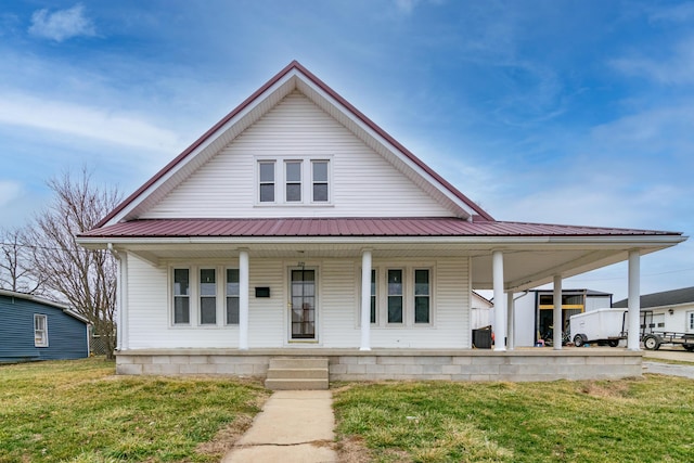 farmhouse-style home featuring covered porch and a front lawn