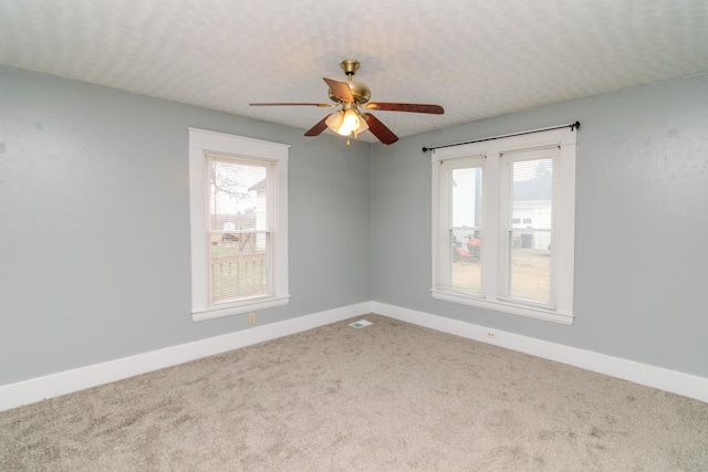 unfurnished room featuring ceiling fan, plenty of natural light, a textured ceiling, and carpet flooring