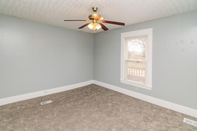 carpeted empty room featuring ceiling fan and a textured ceiling