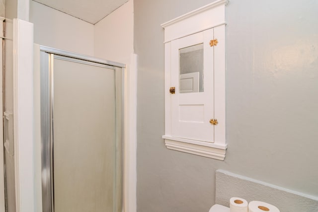 bathroom with toilet and a shower with shower door