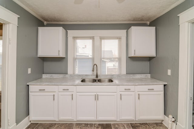 kitchen featuring crown molding, sink, a textured ceiling, and white cabinets