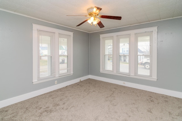 spare room featuring crown molding, carpet, and a wealth of natural light