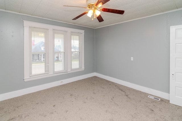 spare room with ceiling fan, ornamental molding, and carpet floors