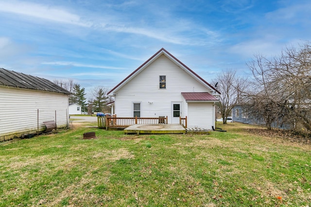 rear view of property with a yard and a deck