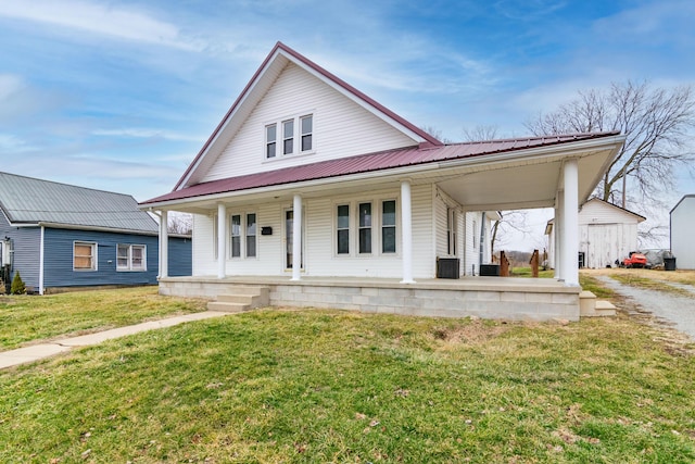 farmhouse with central AC unit, covered porch, and a front yard