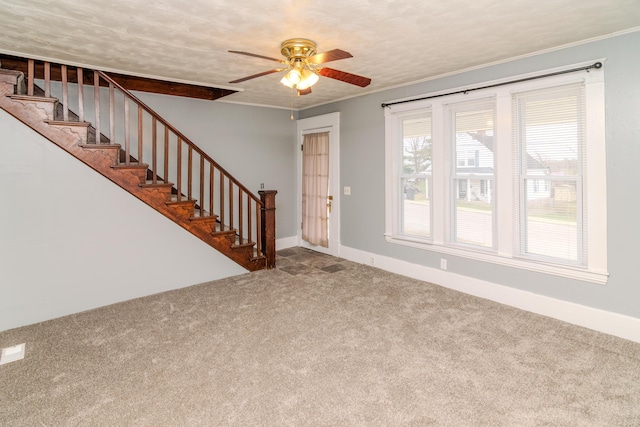 unfurnished living room with crown molding, carpet flooring, and ceiling fan