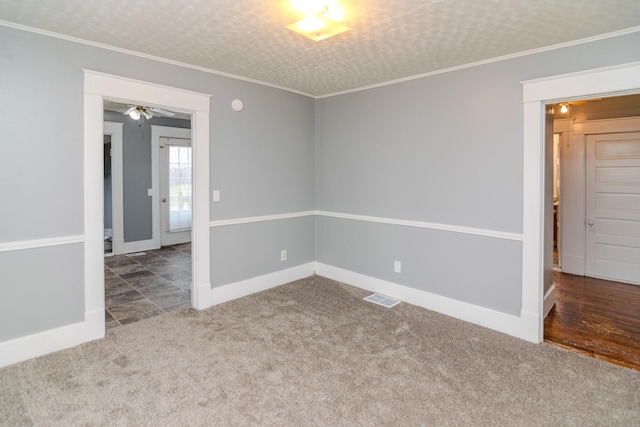 carpeted empty room featuring ornamental molding and a textured ceiling