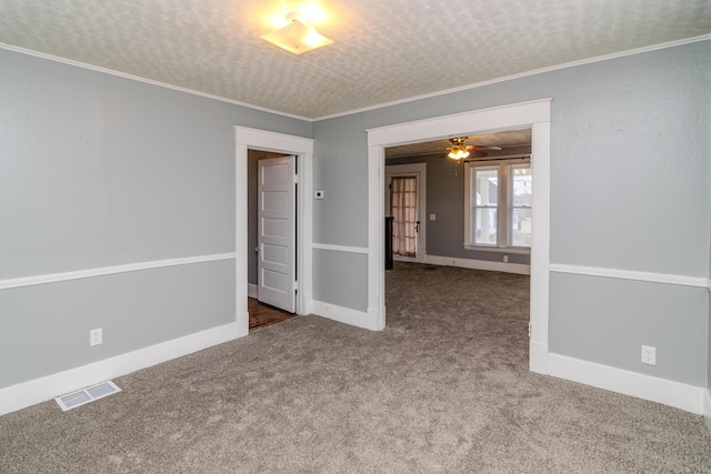 carpeted spare room featuring crown molding and a textured ceiling