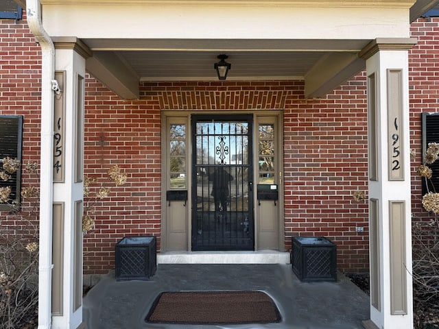 view of exterior entry with brick siding