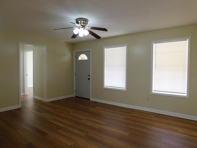 foyer with dark wood-type flooring, a ceiling fan, and baseboards