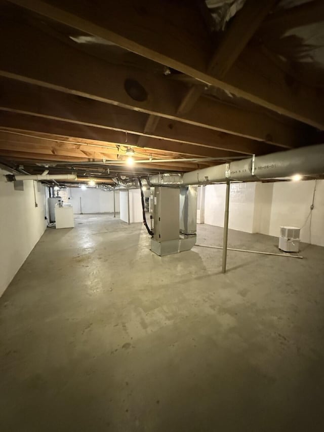 basement featuring heating unit and water heater