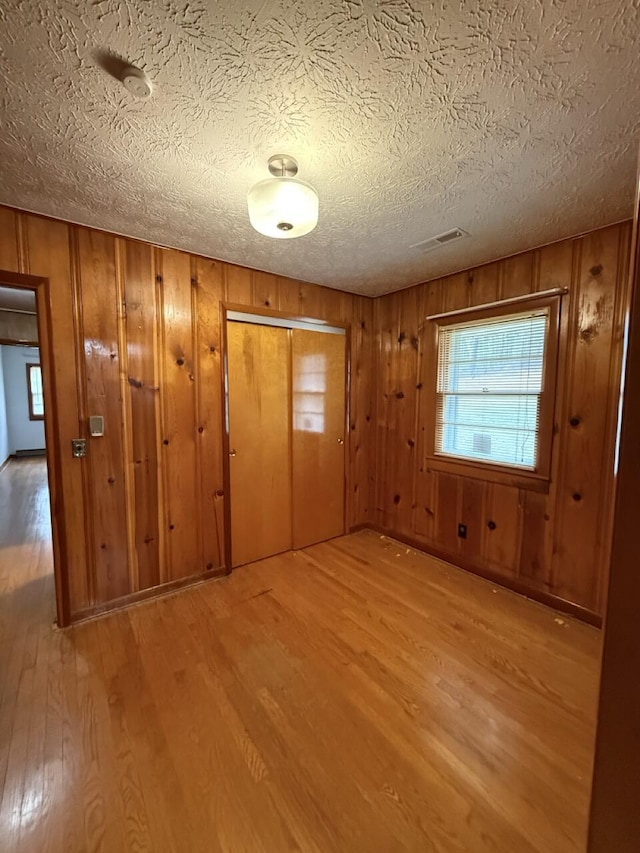 foyer entrance with a textured ceiling and light wood-type flooring