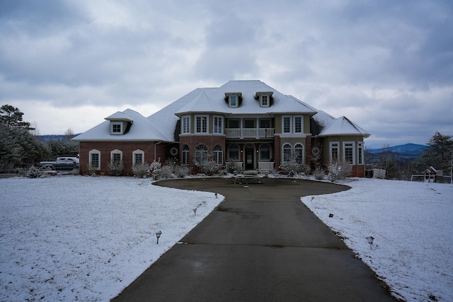 view of front facade featuring driveway, a mountain view, and brick siding