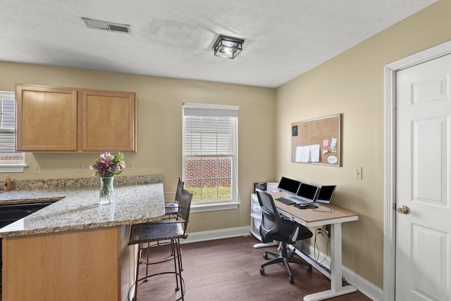 office with dark wood-type flooring and a textured ceiling