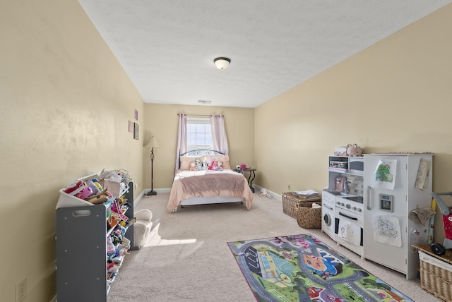 carpeted bedroom featuring a textured ceiling and refrigerator