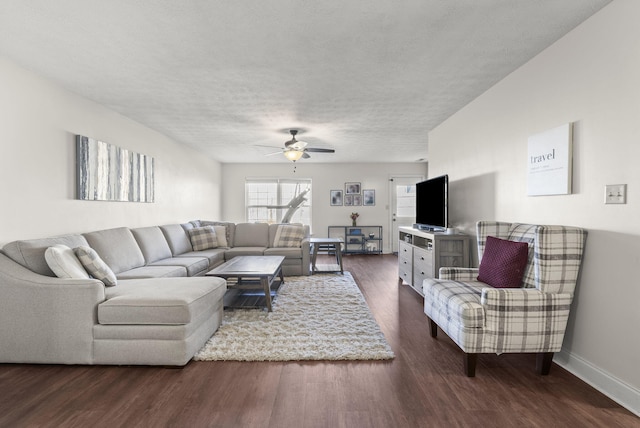 living room with ceiling fan, a textured ceiling, and dark hardwood / wood-style flooring