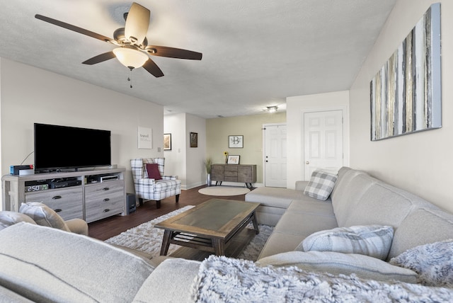 living room with dark hardwood / wood-style flooring, a textured ceiling, and ceiling fan