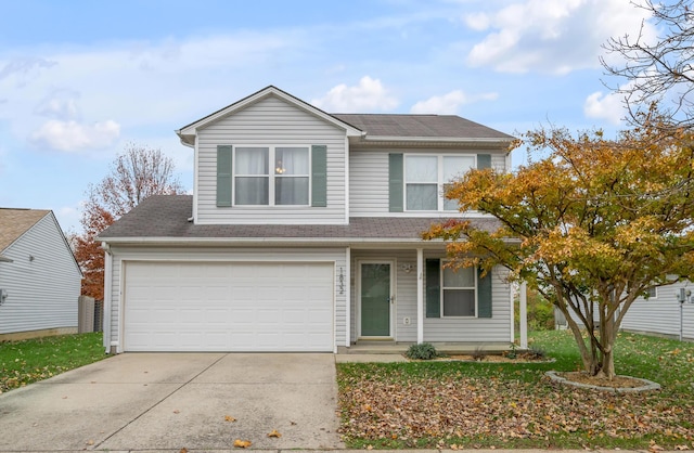 traditional-style house featuring a garage, driveway, and a shingled roof