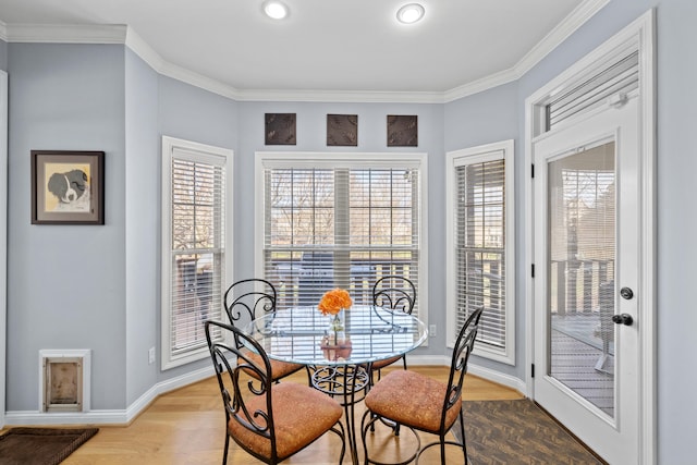 dining room featuring crown molding, baseboards, and wood finished floors