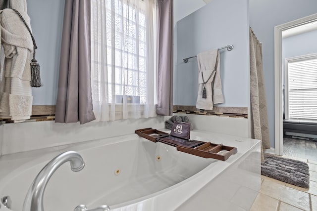 full bath with a whirlpool tub and tile patterned floors