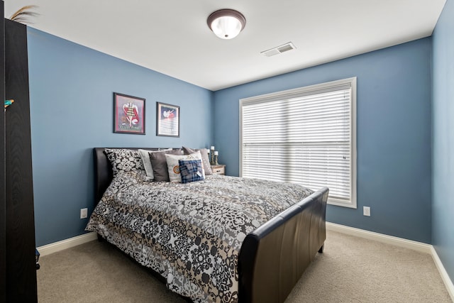 bedroom featuring baseboards, visible vents, and light colored carpet