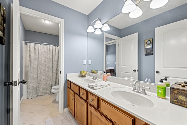 bathroom with double vanity, a sink, toilet, and tile patterned floors