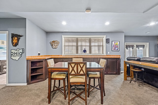 dining space featuring light carpet, baseboards, and recessed lighting