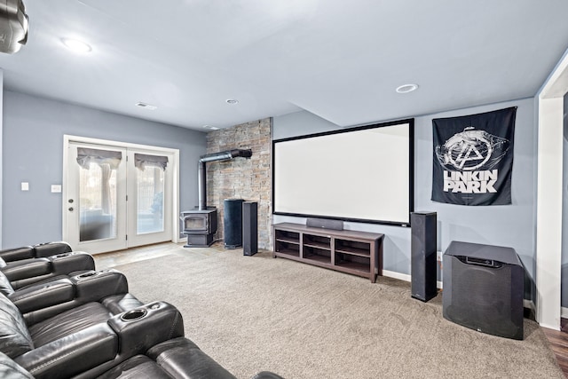 home theater room featuring visible vents, carpet, a wood stove, and recessed lighting